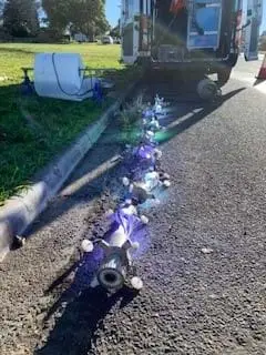 A UV light train being pulled along a footpath into a pipe